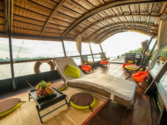 Elegante cabina di una crociera fluviale sul Mekong con confortevoli sedie a sdraio, ideale per godere delle rilassanti vedute delle acque cambogiane.