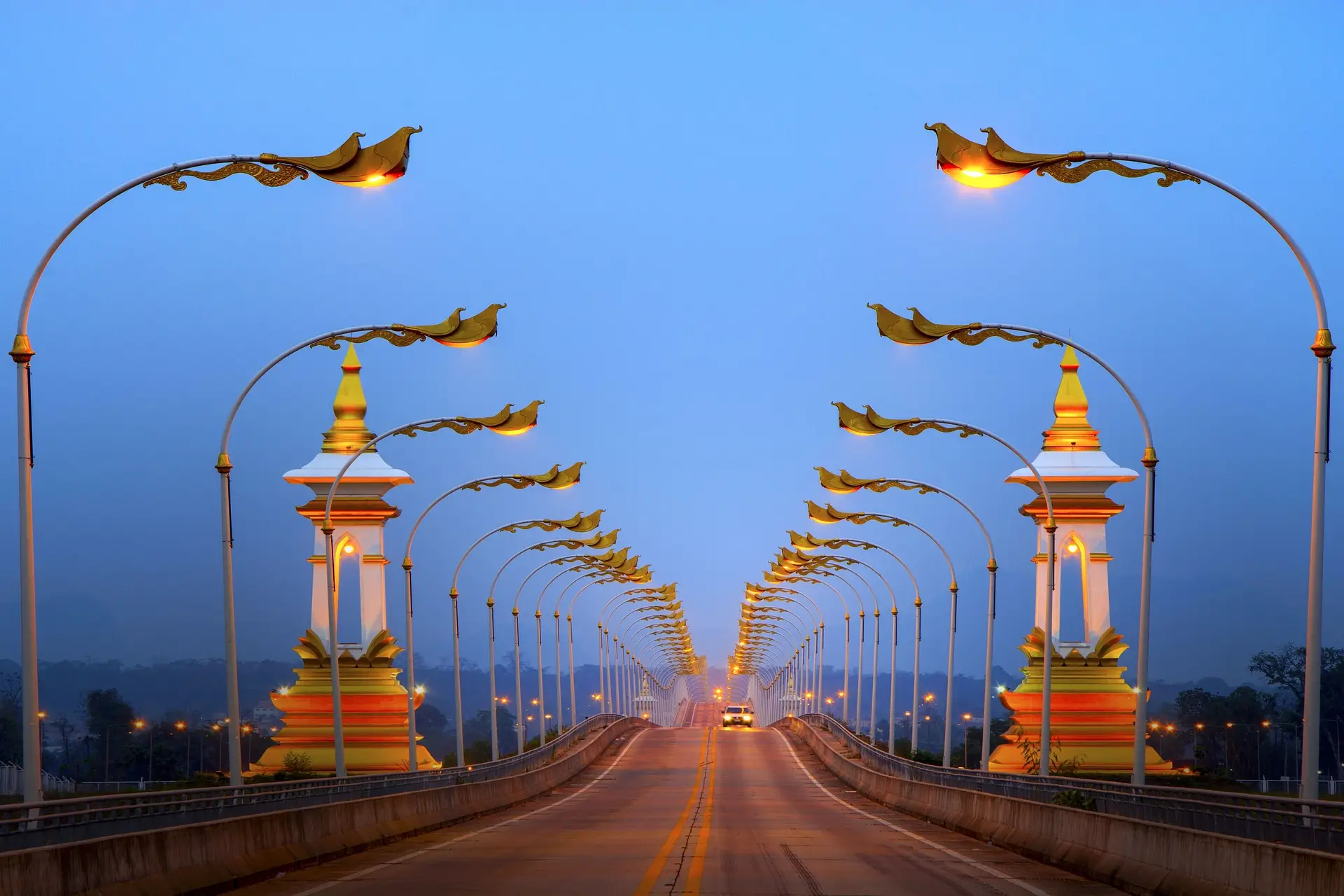 Ponte dell'Amicizia Laos illuminato al crepuscolo, simbolo di connessione e ingresso culturale tra il Laos e i paesi confinanti.