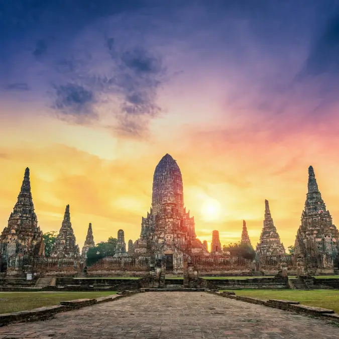 Rovine di templi antichi ad Ayutthaya durante un tramonto suggestivo, testimonianza della storia thailandese, destinazione fondamentale per gli appassionati di archeologia asiatica.