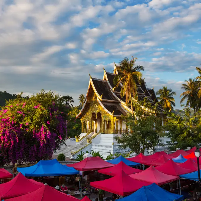 Il maestoso Tempio Wat Mai a Luang Prabang, capolavoro dell'architettura laotiana tradizionale, circondato da mercati colorati, attrazione culturale essenziale in Laos.