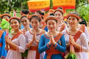 Un gruppo di donne vietnamite vestite con abiti tradizionali etnici si unisce in una preghiera pacifica, riflettendo la spiritualità e le tradizioni delle minoranze etniche del Vietnam